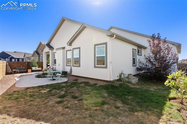 back of house featuring a patio and a lawn