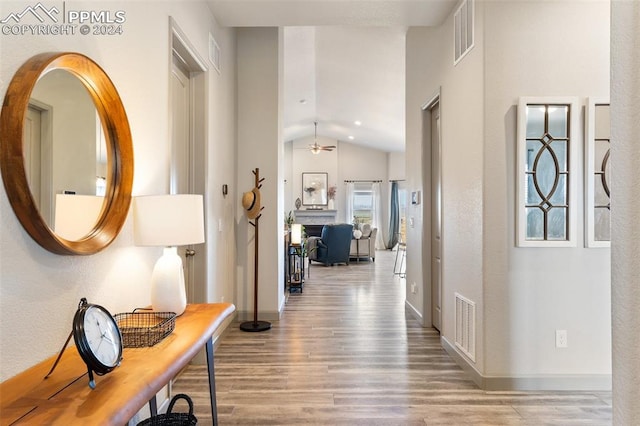 corridor featuring lofted ceiling and hardwood / wood-style floors