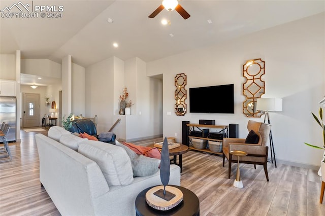 living room with ceiling fan, lofted ceiling, and light wood-type flooring