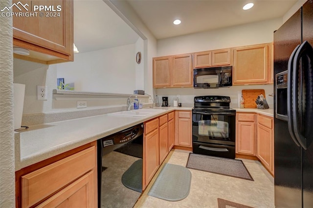 kitchen with sink, black appliances, light brown cabinets, and light tile patterned floors