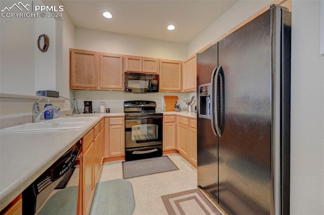 kitchen featuring sink, black appliances, light brown cabinets, and light tile patterned floors