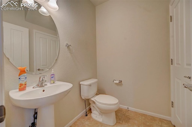 bathroom with toilet and tile patterned flooring