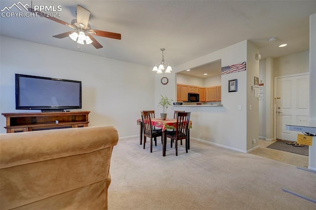 dining area with light colored carpet and ceiling fan with notable chandelier