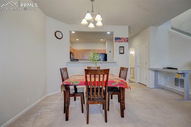 carpeted dining area featuring a chandelier