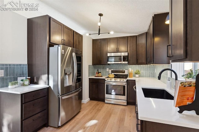 kitchen featuring dark brown cabinets, sink, light wood-type flooring, and stainless steel appliances