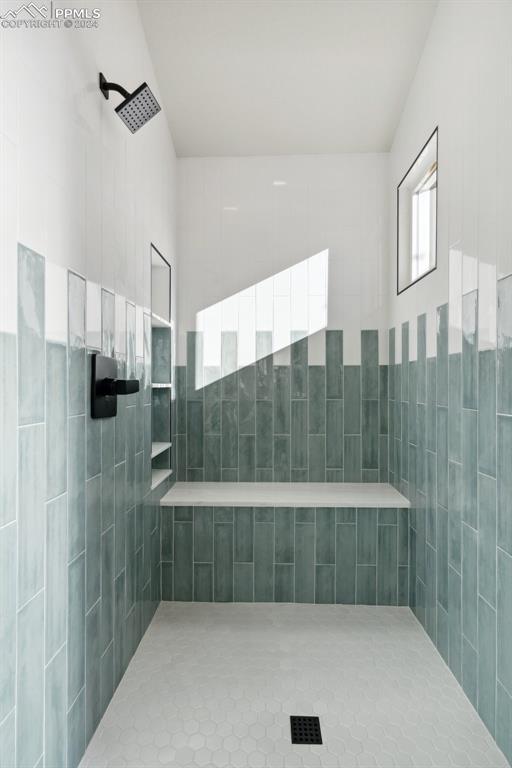 bathroom featuring tile patterned flooring and a tile shower