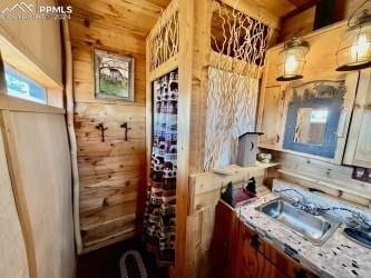 wine room featuring wood ceiling, wood walls, and sink