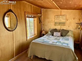 bedroom with wooden walls and wood ceiling