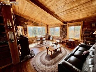 living room with lofted ceiling, hardwood / wood-style floors, wooden walls, and wooden ceiling