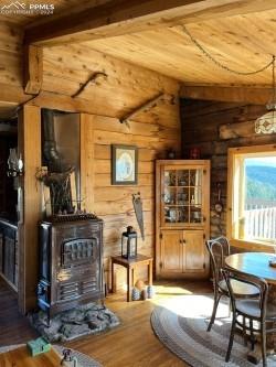 bar with wood ceiling, a wood stove, lofted ceiling with beams, and wood-type flooring