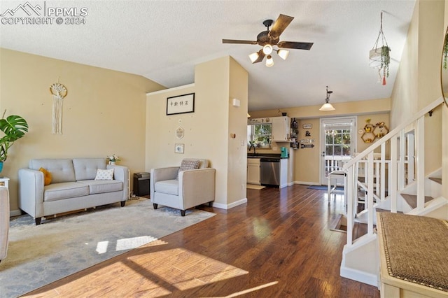 living room with dark hardwood / wood-style flooring, a textured ceiling, ceiling fan, and vaulted ceiling