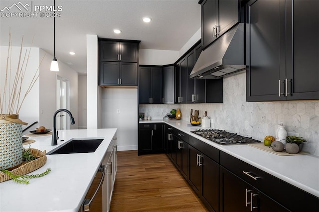 kitchen featuring dark hardwood / wood-style floors, backsplash, sink, pendant lighting, and appliances with stainless steel finishes