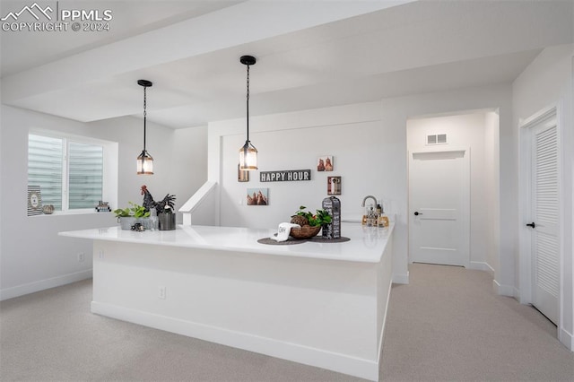 kitchen featuring light carpet, kitchen peninsula, and hanging light fixtures