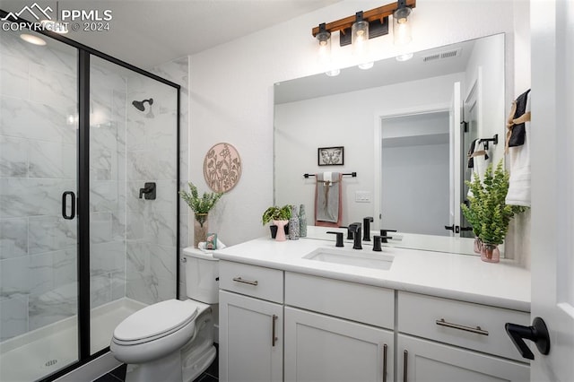 bathroom featuring vanity, toilet, and a shower with shower door