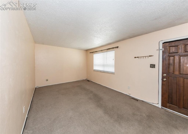 carpeted spare room featuring a textured ceiling