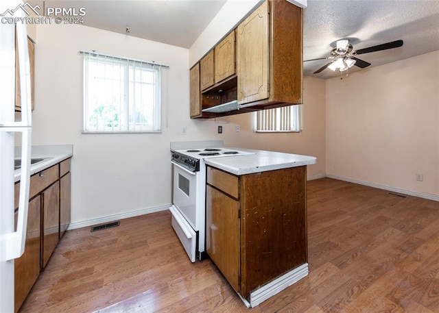 kitchen featuring electric range, a textured ceiling, light hardwood / wood-style floors, and ceiling fan