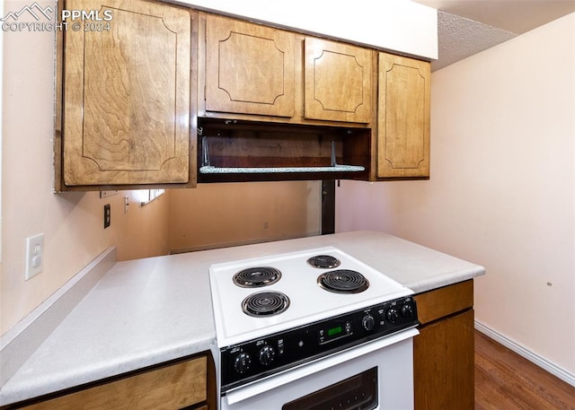 kitchen featuring white range with electric stovetop, dark hardwood / wood-style floors, and a textured ceiling