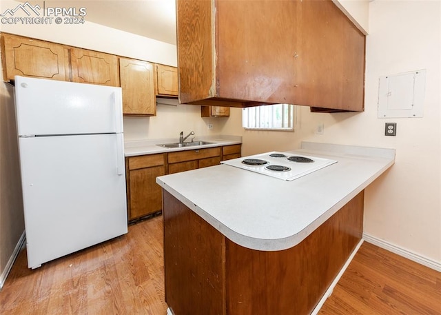 kitchen with kitchen peninsula, electric panel, light hardwood / wood-style flooring, sink, and white appliances