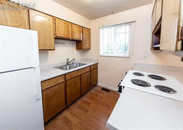 kitchen featuring hardwood / wood-style floors, sink, and white appliances