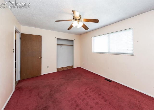 unfurnished bedroom with a textured ceiling, carpet flooring, and ceiling fan