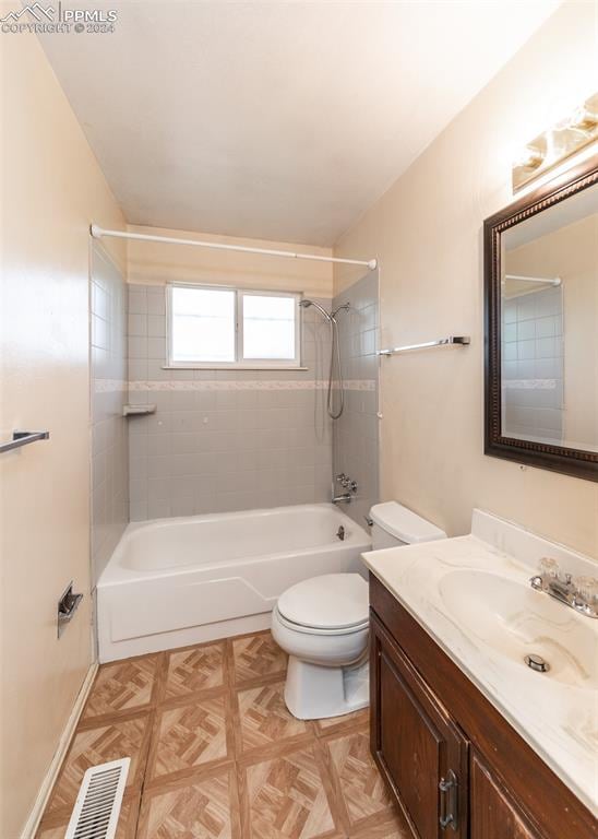 full bathroom with toilet, tiled shower / bath combo, and vanity