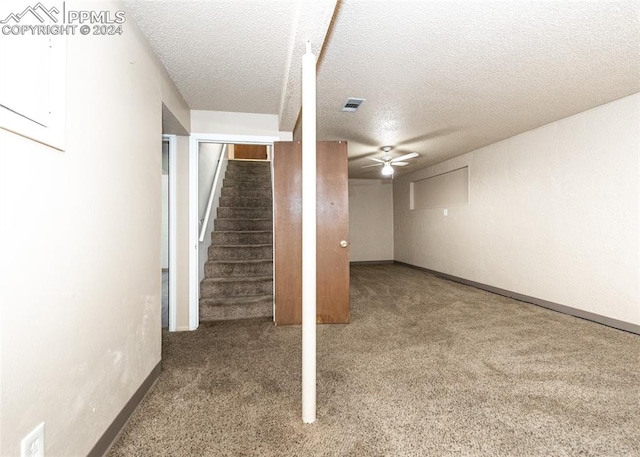 basement with a textured ceiling, carpet flooring, and ceiling fan