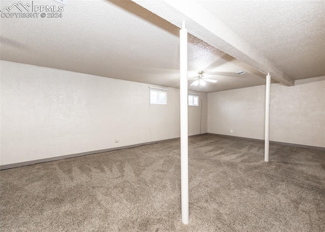 basement featuring a textured ceiling and carpet flooring