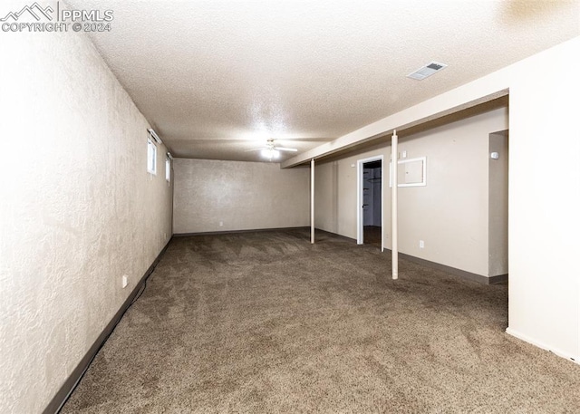 basement with dark colored carpet and a textured ceiling