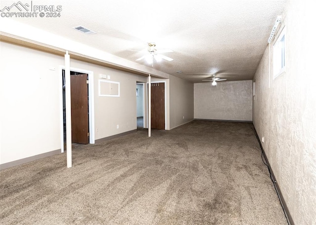 basement with carpet, a textured ceiling, and ceiling fan