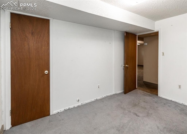 carpeted spare room with a textured ceiling