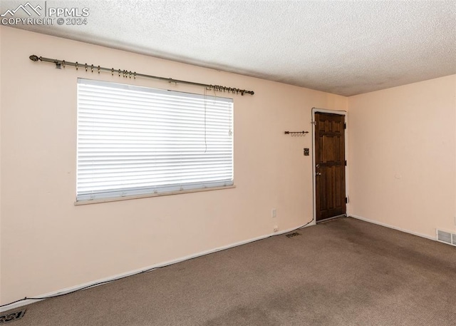 carpeted spare room featuring a textured ceiling