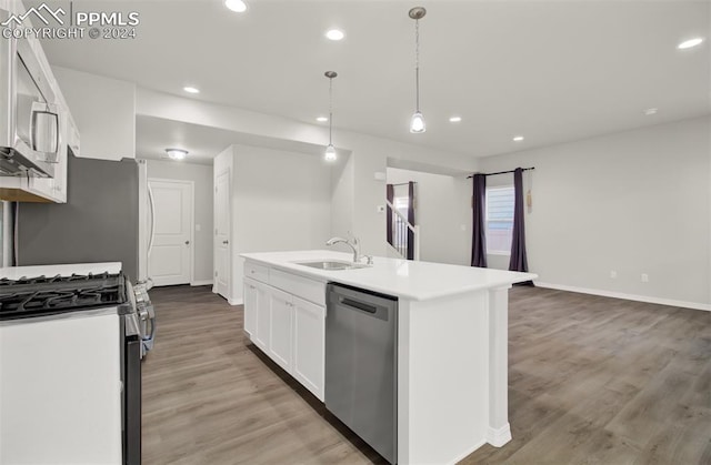 kitchen with white cabinetry, a kitchen island with sink, stainless steel appliances, sink, and decorative light fixtures