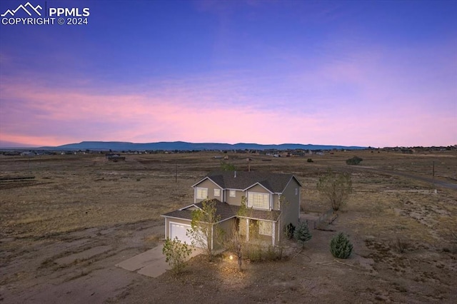 aerial view at dusk with a mountain view and a rural view