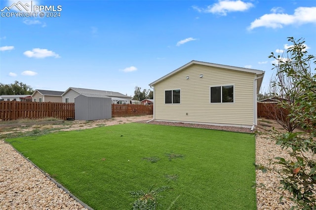 rear view of house featuring a shed and a lawn