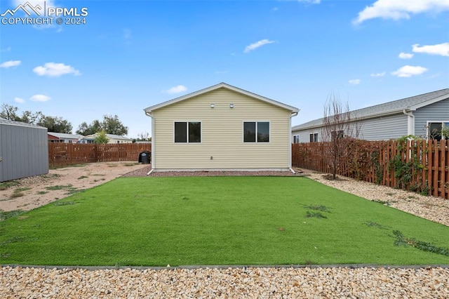 rear view of property featuring a lawn