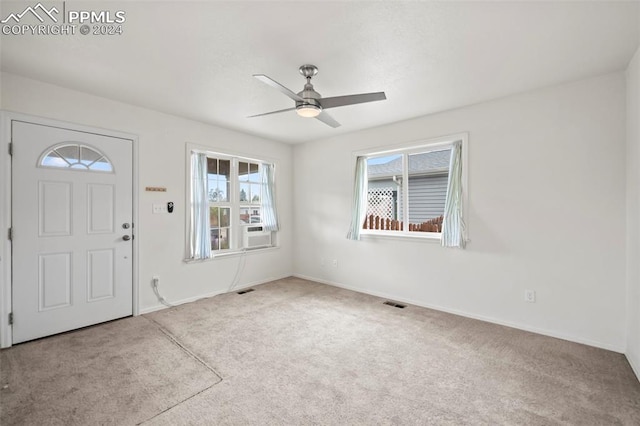 foyer with light carpet, cooling unit, and ceiling fan