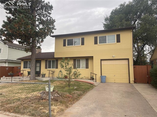 view of property featuring a garage and a front lawn