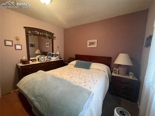 carpeted bedroom featuring a textured ceiling