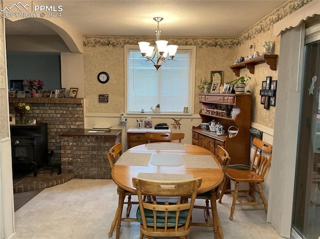 dining space featuring a notable chandelier and a wood stove