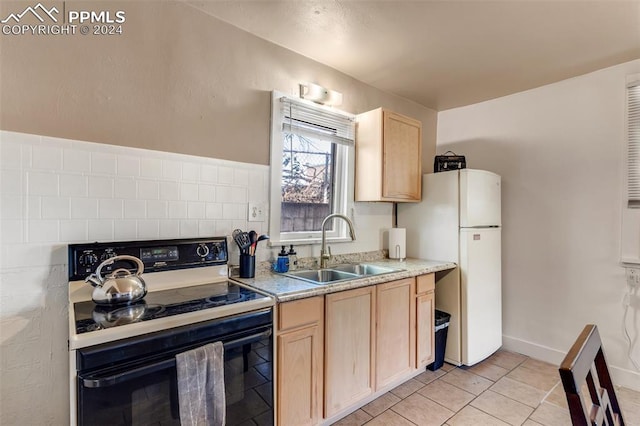 kitchen with light brown cabinets, light tile patterned floors, sink, white refrigerator, and electric stove