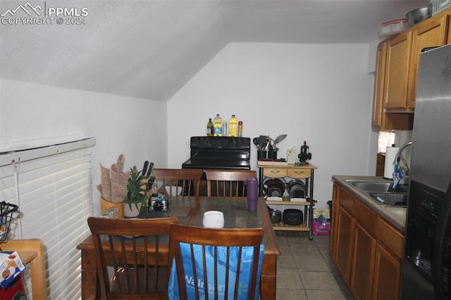 tiled dining space with sink and vaulted ceiling