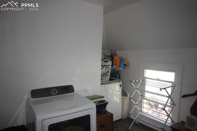 laundry room featuring washer and clothes dryer and dark carpet