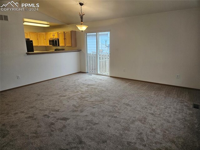 unfurnished living room with carpet flooring and vaulted ceiling