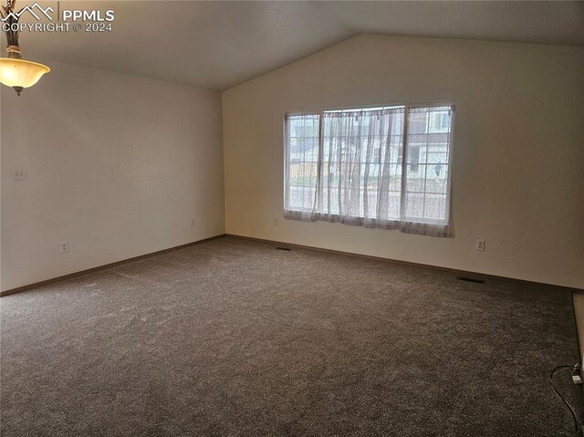 carpeted empty room featuring lofted ceiling