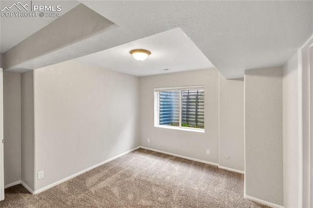 empty room featuring a textured ceiling and carpet