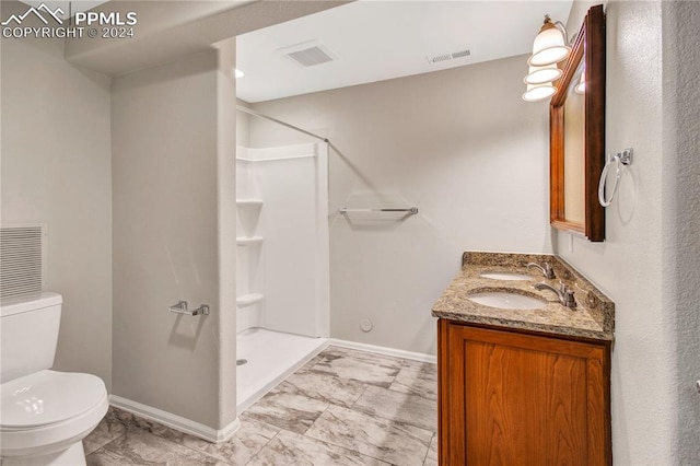 bathroom with vanity, a shower, and toilet