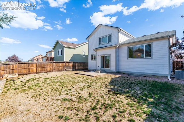 rear view of property featuring a patio area and a lawn