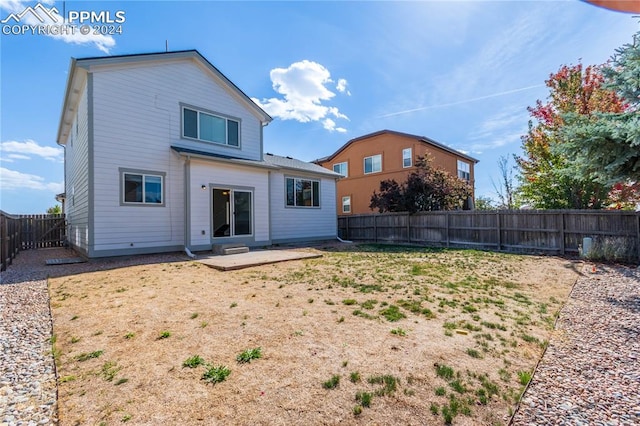 back of house with a patio and a yard