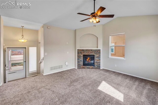 unfurnished living room featuring ceiling fan, lofted ceiling, a fireplace, and carpet floors