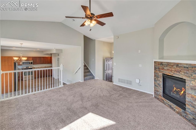 unfurnished living room with lofted ceiling, carpet, a fireplace, and an inviting chandelier